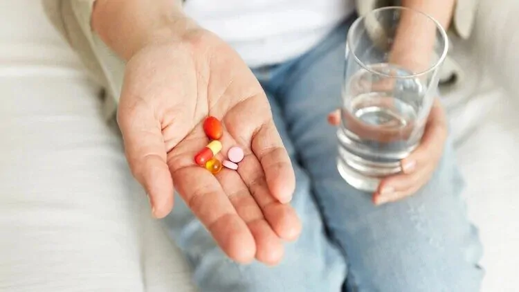 antibiotici-i-probiotici Zena drzi kapsule i tablete na dlanu