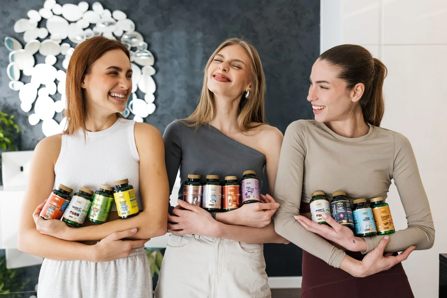 Tri djevojke koje se smiju s Hug Your Life dodatcima prehrani u rukama