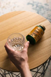 Bocica Hug Your Life Kurkumin C3 Komplexa na stolicu pored case vode