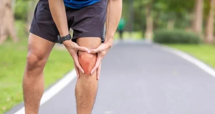 Bolesti zglobova Muškarac trči u prirodi i uhvatio se za koljeno jer ima upalu zglobova