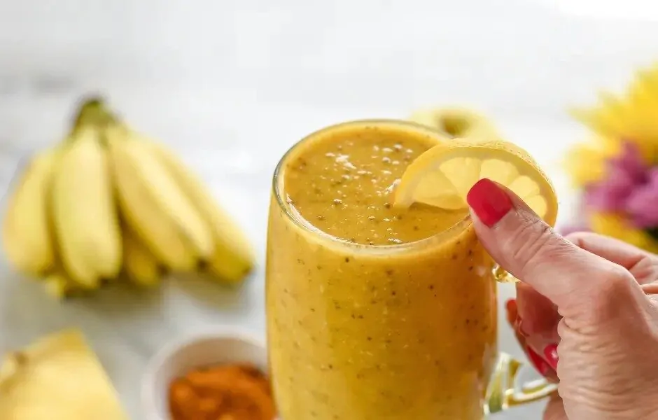 Protuupalni smoothie s kurkumom poslužen u čaši s kriškom limuna